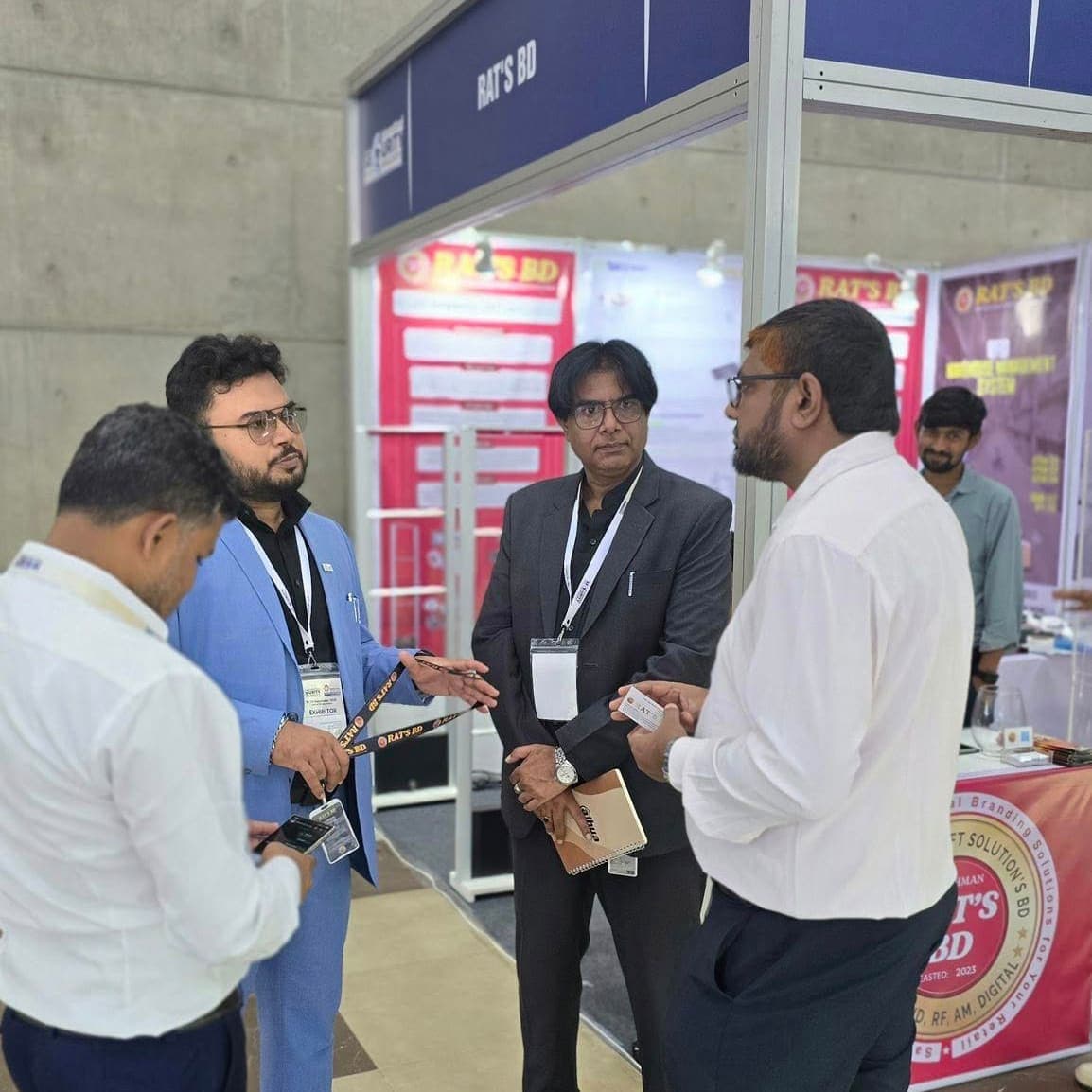 Four visitors in conversation at the RATS BD stand at the International Security Expo Bangladesh, under the company's booth fascia