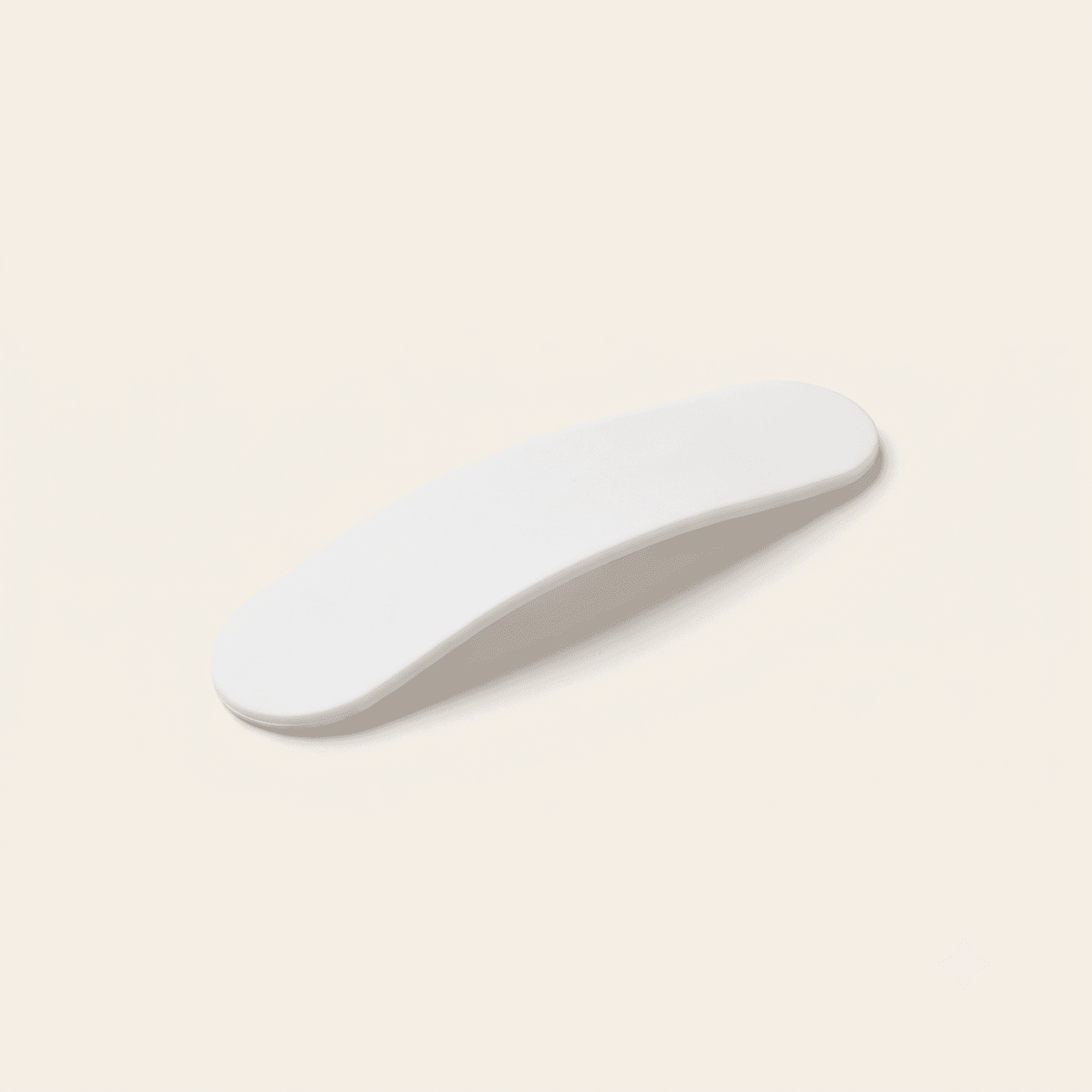 Flexible white silicone laundry RFID tag, curved as if just removed from fabric